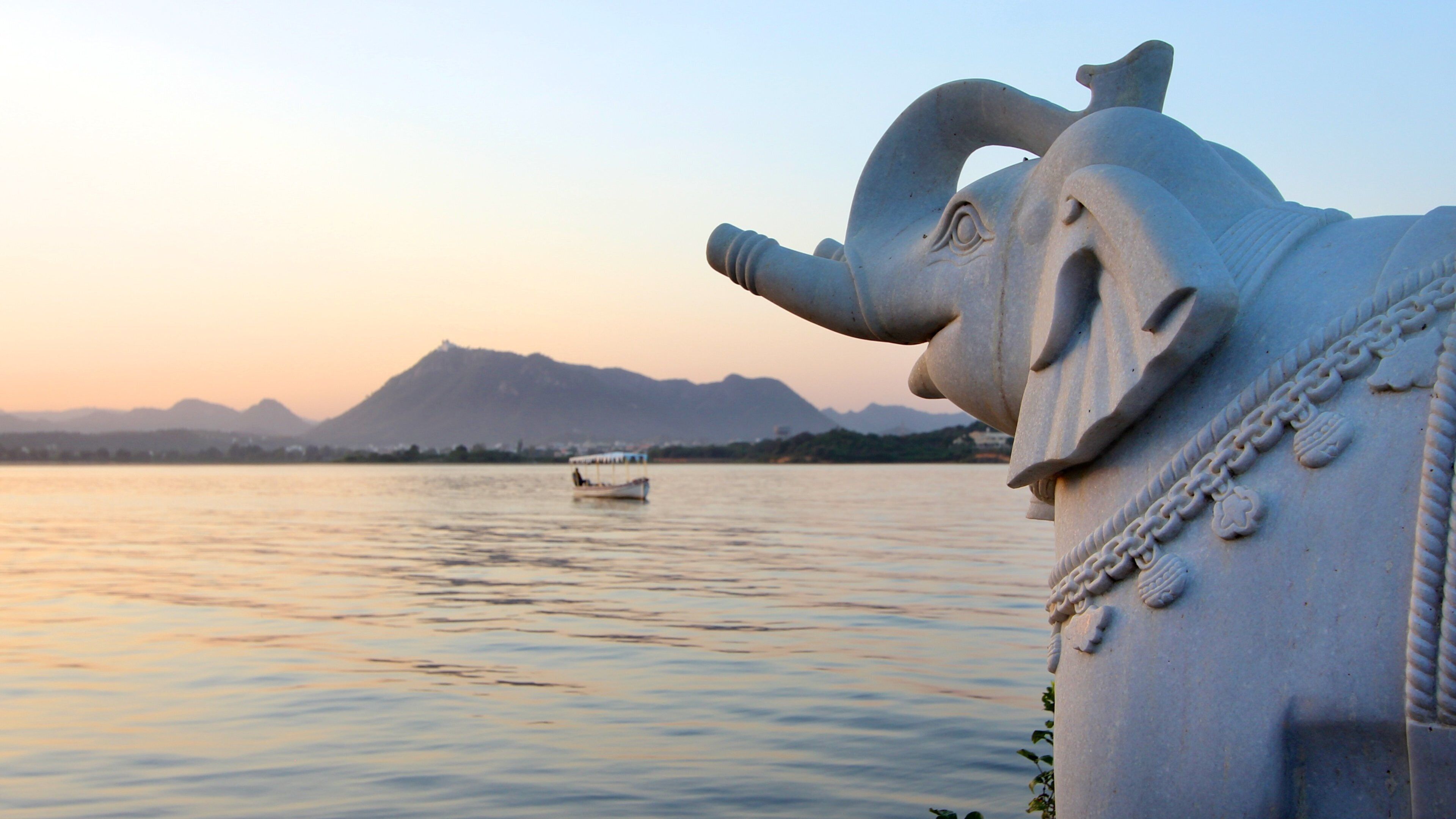 City Palace showing outdoor art, a sunset and a lake or waterhole