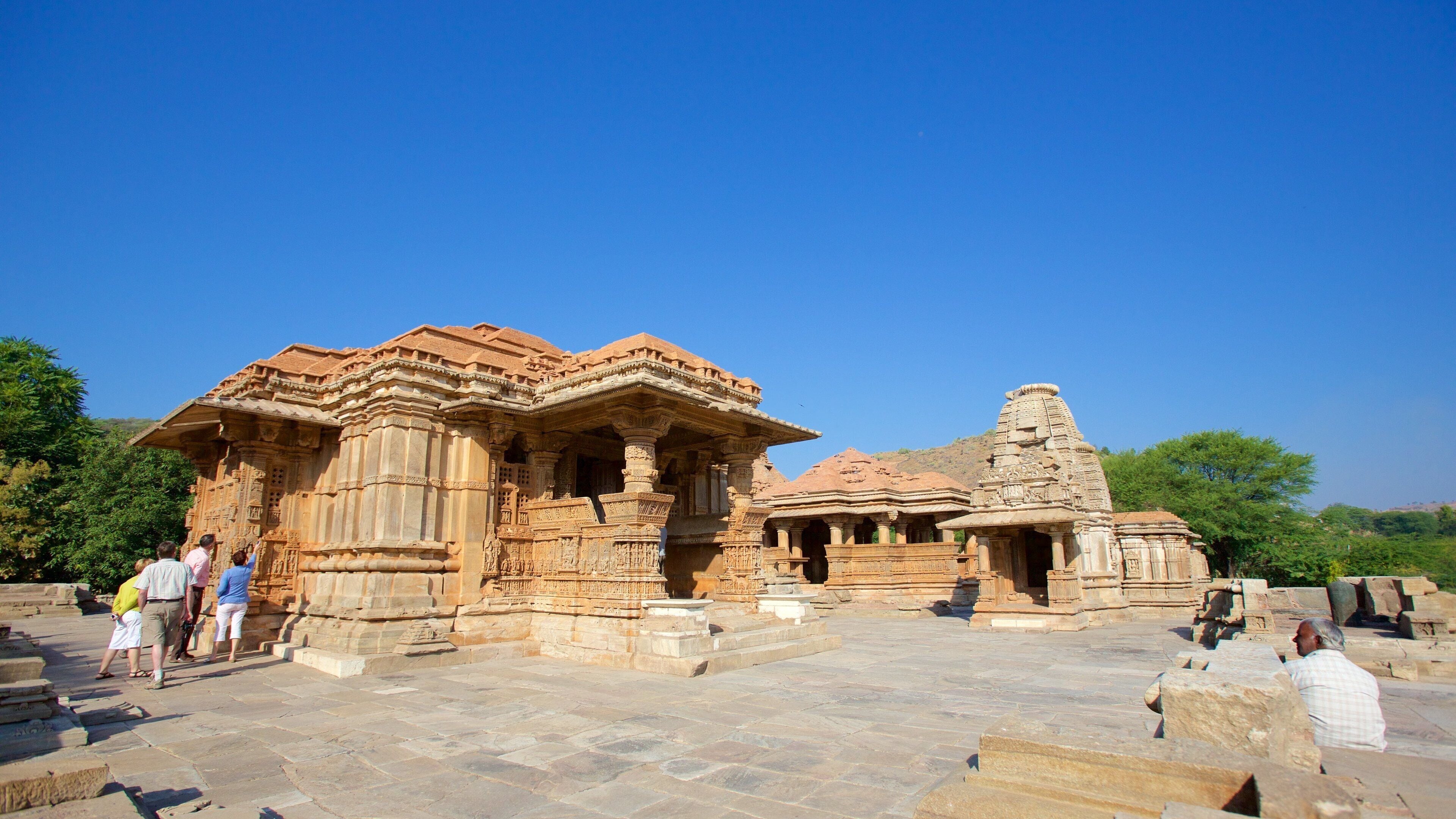 A historical temple complex with intricate carvings and a clear blue sky.