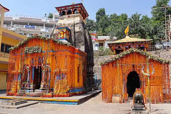 Un temple décoré de guirlandes de souci orange et abritant une statue d’une divinité.