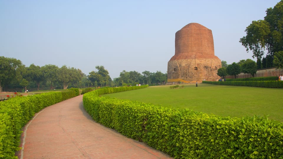 A pathway leading to a large, dome-shaped structure surrounded by lush greenery.