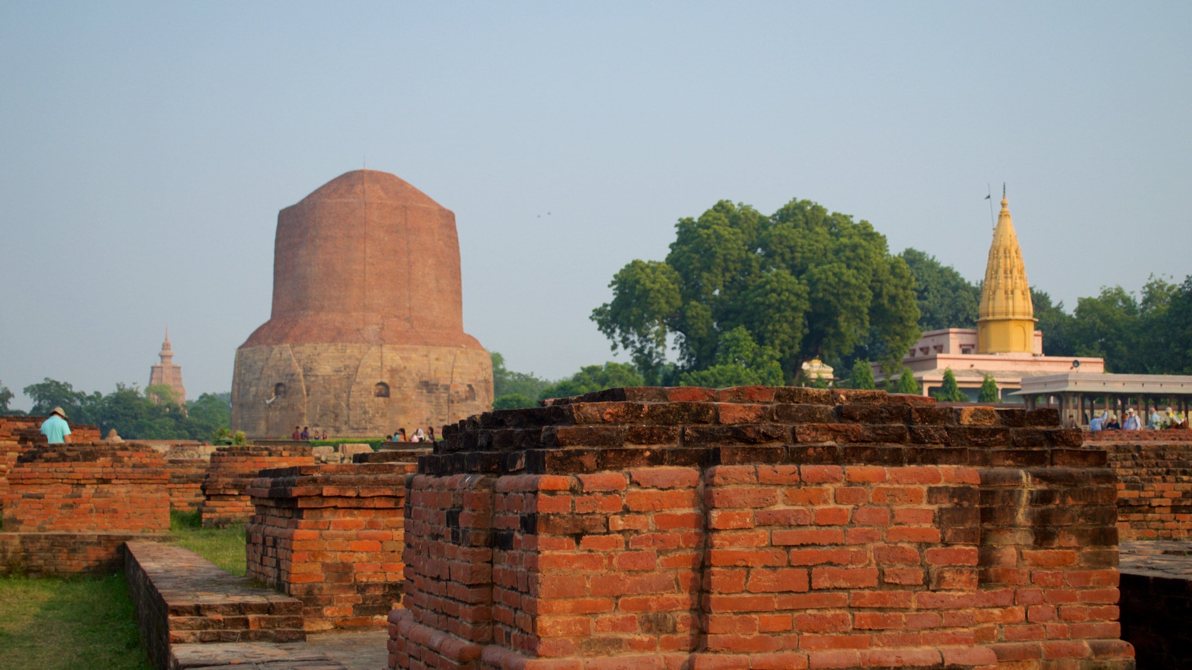A large brick structure, a golden spire, and a pagoda in the background.
