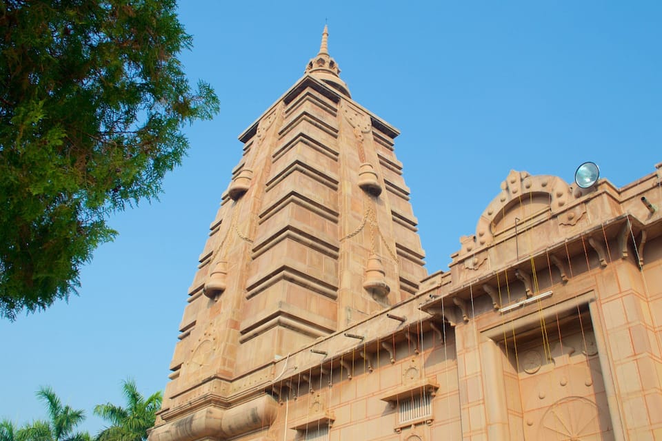 A tall, ornate building with a pointed roof and intricate carvings.