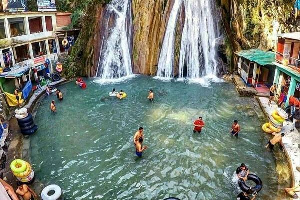 restaurants.
Kempty Falls is a magnificent waterfall and recreation area set in the lap of a green valley. Itâs a favorite hangout of local residents, who come to cool off in waterholes, have fun with relaxed boating activities and enjoy scenic picnics. A British officer established Kempty Falls in the 1830s as a place for the British Raj to hold tea parties. The waterfallâs name is rumored to stem from the colloquial name of Camp Tea.
Follow the walkways and bridges that lead from the fallsâ entrance to vantage points. Marvel as the milky-white water cascades down a cliff face before bouncing off rocks and into a manmade waterhole. Admire the verdant foliage that frames both sides of the waterfall. Listen to the invigorating sounds of the rushing water, which mingles with the excited cheering of visitors.
On a warm and sunny day you might want to take a refreshing dip in the inviting pool. Inflatable rings are available to rent and present the chance to float lazily on the shallow water. Stand directly beneath one of the branches of the falls to experience its full force. Around the pool, find restaurants serving traditional Indian snacks and a handful of shops selling curios.
A short walk past the main waterhole is a small water park, complete with a collection of terraced pools. Here you can enjoy safe swimming, ride waterslides and rent paddleboats.
Access to the falls is via a short cable-car ride that travels down a forest-covered mountainside. As you move deep into the valley, take time to check out the colorful Tibetan-style homes which sit precariously on the cliffs. An alternative way to get here is to walk down a series of hillside steps.
The waterfall is about a 30-minute drive from Mussoorieâs town center and easily accessible via auto-rickshaws and taxis. Combine your visit with a walk around nearby Happy Valley, a Tibetan community nestled amid a green forest. Visit a Buddhist temple and look inside to see artisan workshops.
Kempty Falls is open daily. There is a fee for the cable car and the attractions at the waterpark.