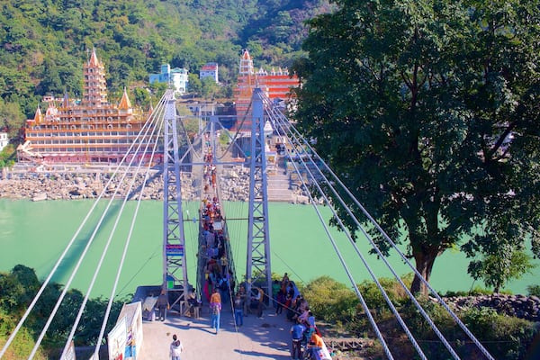 Lakshman Jhula which includes a river or creek, a suspension bridge or treetop walkway and a small town or village