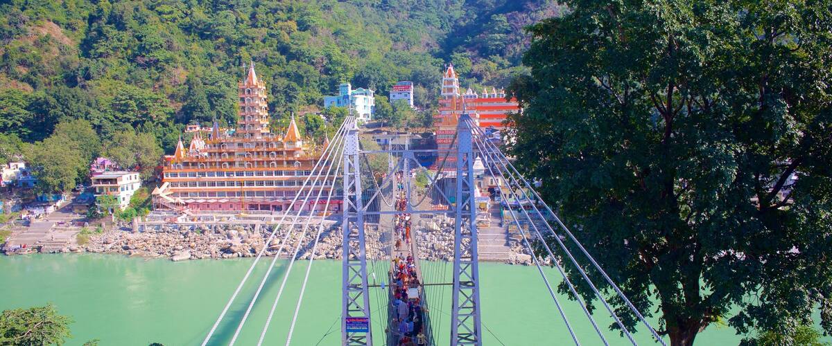 Lakshman Jhula which includes a river or creek, a suspension bridge or treetop walkway and a small town or village