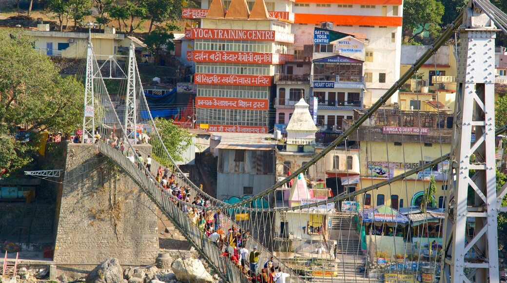Lakshman Jhula which includes a suspension bridge or treetop walkway and a city as well as a large group of people