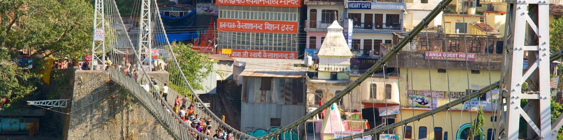 Lakshman Jhula which includes a suspension bridge or treetop walkway and a city as well as a large group of people