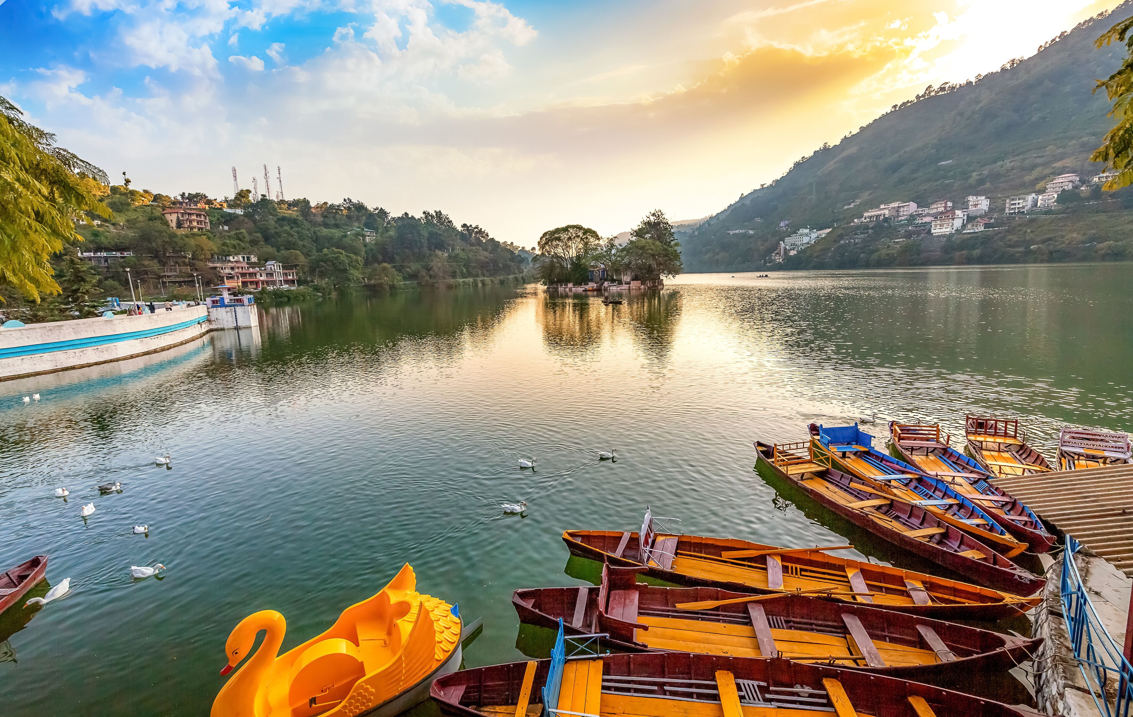 Scenic Bhimtal lake at sunset with wooden tourist boats at Nainital Uttarakhand India.