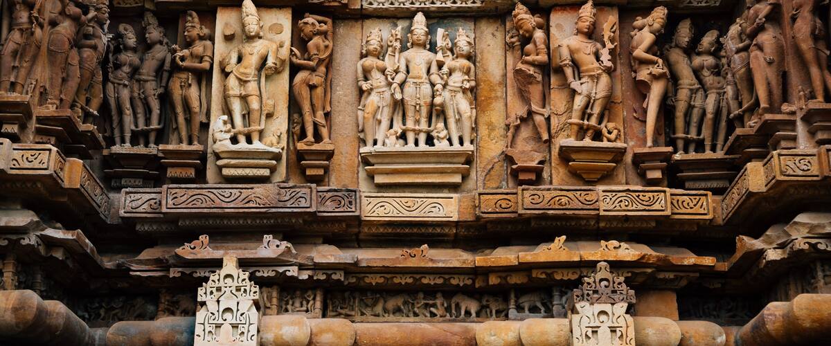 Intricate stone carvings of deities and mythological figures on a temple wall.