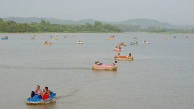 Un lago tranquilo con numerosos botes pequeños dispersos sobre el agua.