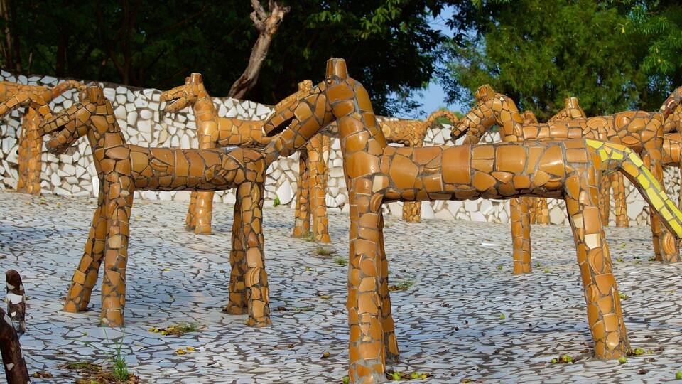 A mosaic sculpture of giraffes on a tiled ground.