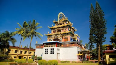 Un templo tradicional de varios niveles con ornamentadas decoraciones doradas, rodeado de palmeras y otra vegetación.