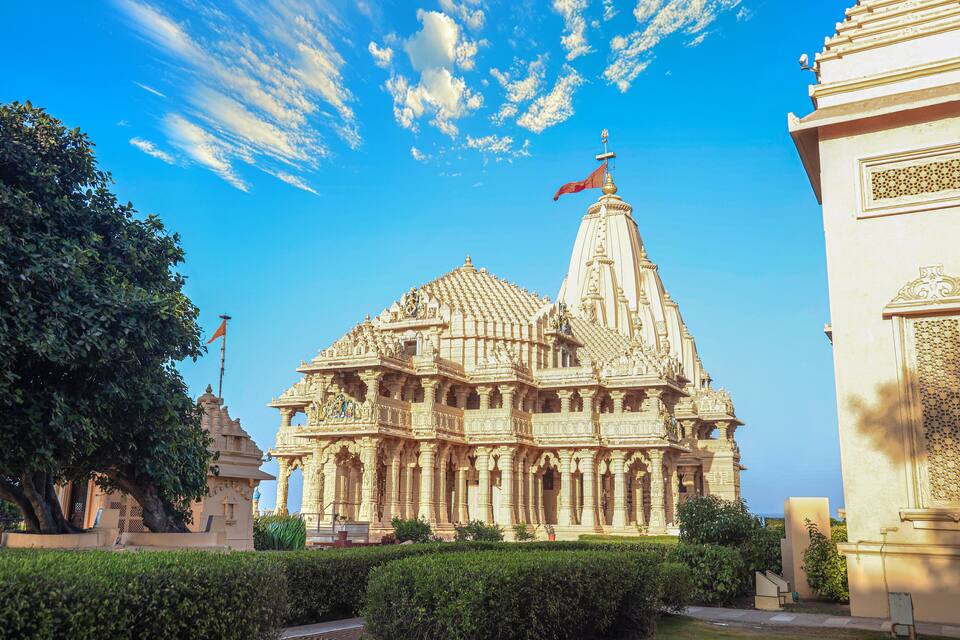A large, ornate temple with intricate carvings and a flag on top.