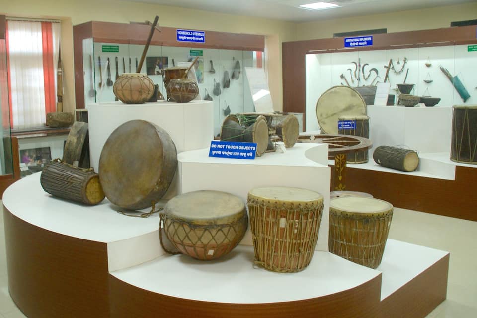 Una exposició de museu amb tambors tradicionals i utensilis domèstics.