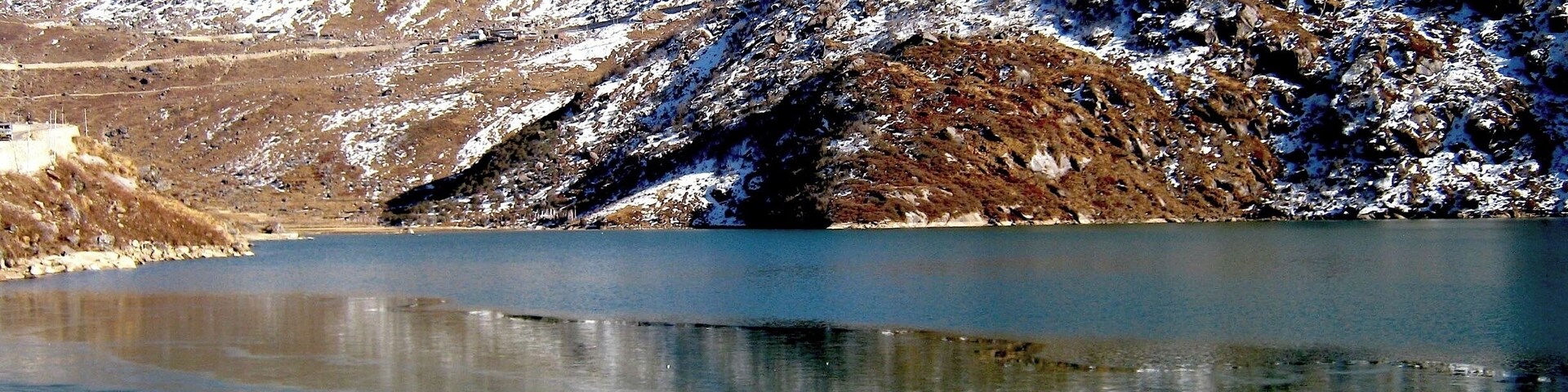 Un lago congelado con montañas nevadas al fondo.