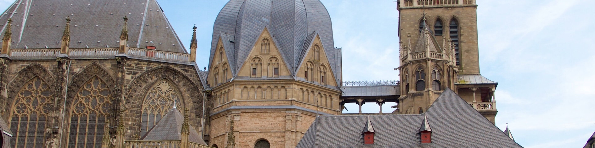 Una catedral histórica con una cúpula grande, arcos apuntados y una torre del reloj.
