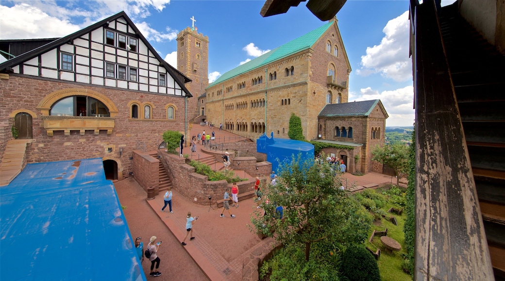 Wartburg Castle featuring a church or cathedral and heritage architecture as well as a small group of people