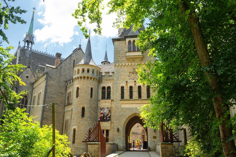 Eine historische Burg mit Steinarchitektur, einem markanten Turm und einem Rundbogenportal.