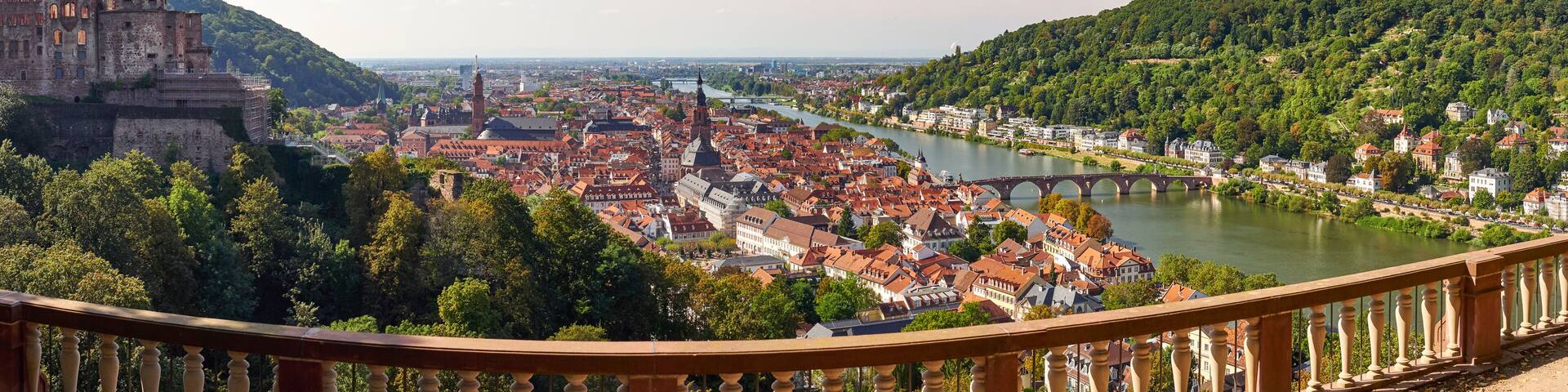 A historic city with a river, a bridge, and a castle on a hill.