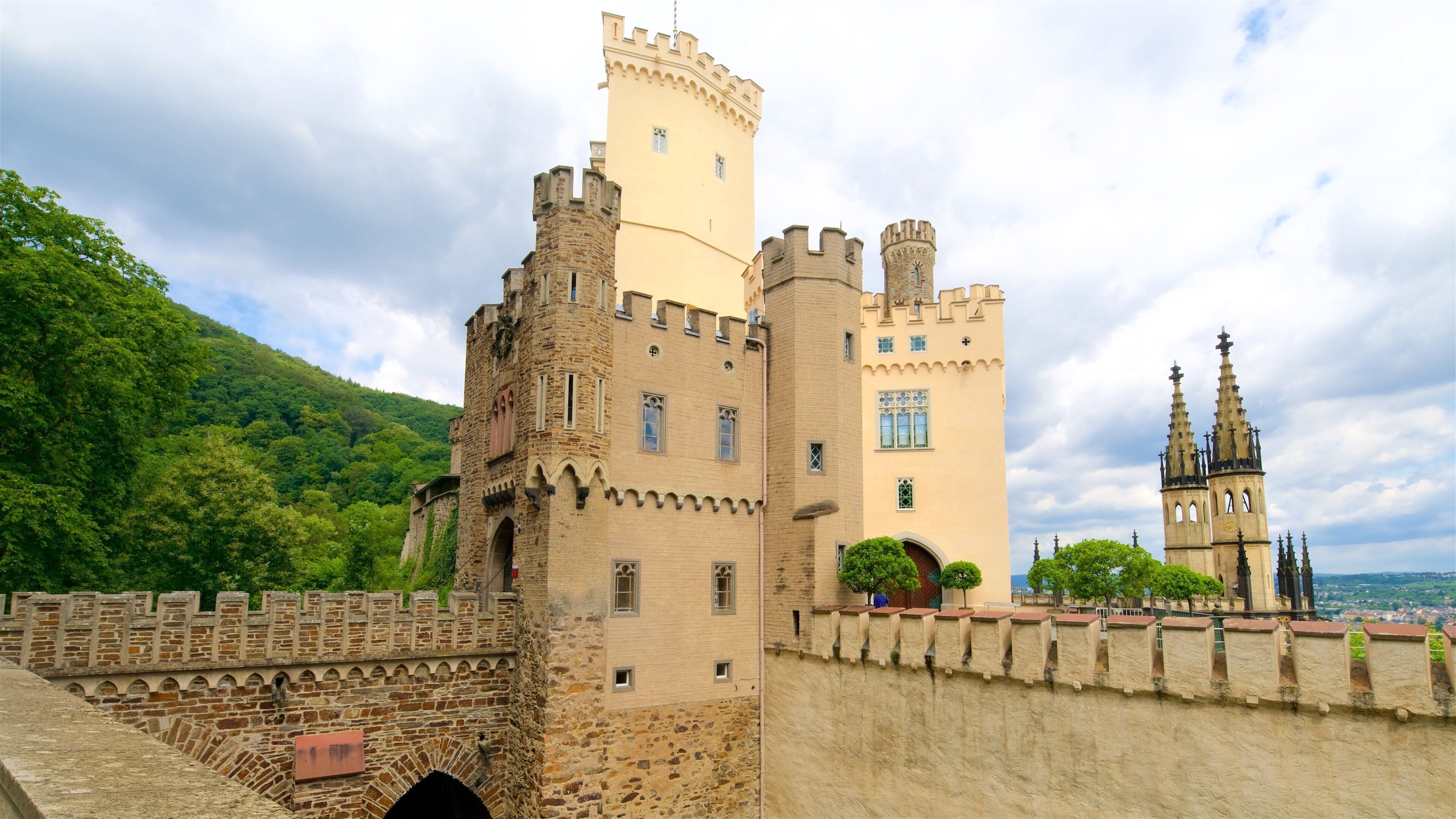 A historic castle with multiple towers and a prominent church in the background.