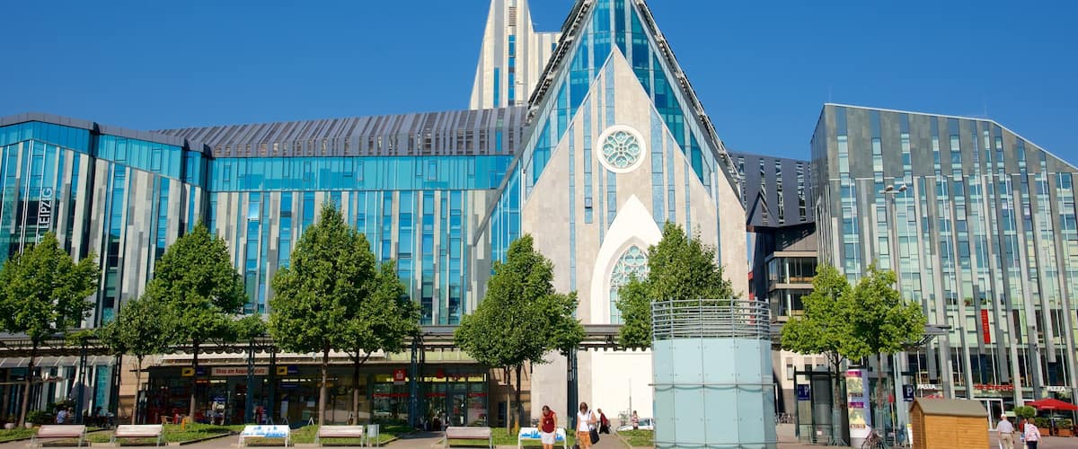 A modern building with a prominent spire and a large glass facade.
