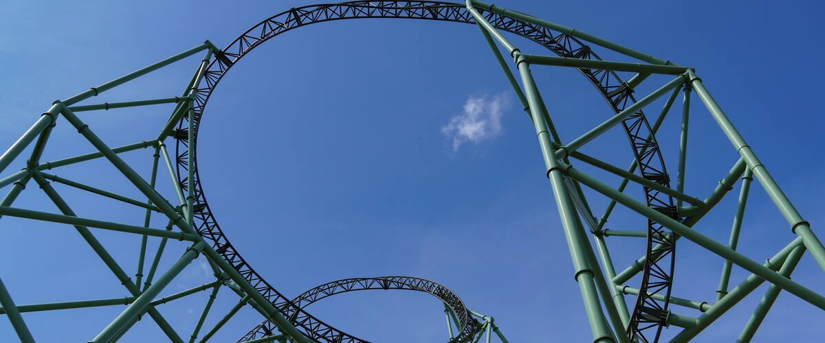 Sierksdorf, Germany - April.30.2022: Green-coloured rollercoaster track and huge construction of an extreme coaster at "Hansa-Park" in Germany