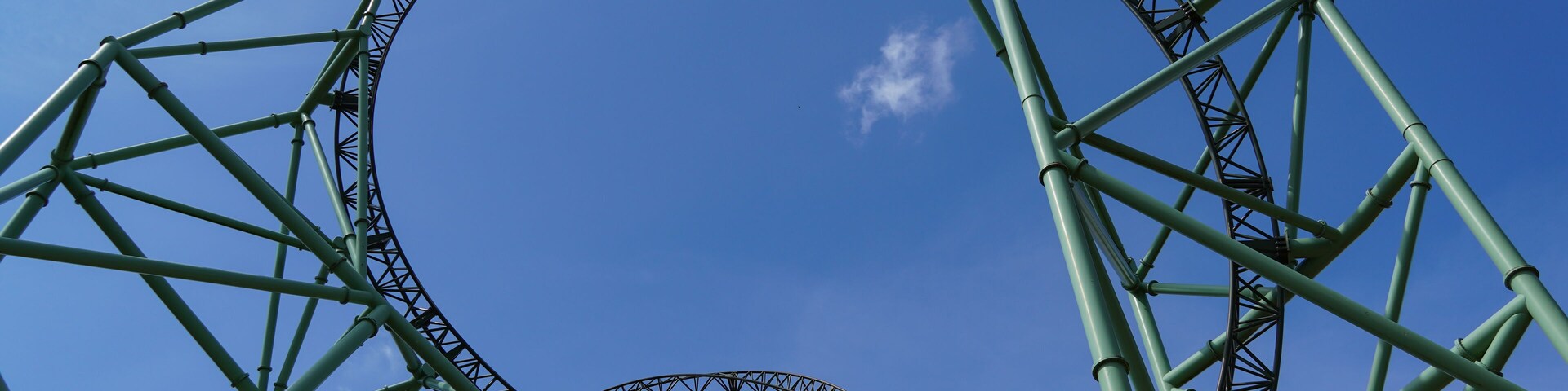 Sierksdorf, Germany - April.30.2022: Green-coloured rollercoaster track and huge construction of an extreme coaster at "Hansa-Park" in Germany