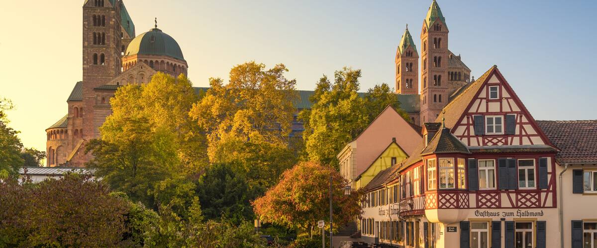 A historic church with twin spires, a traditional half-timbered building, and a cobblestone street.