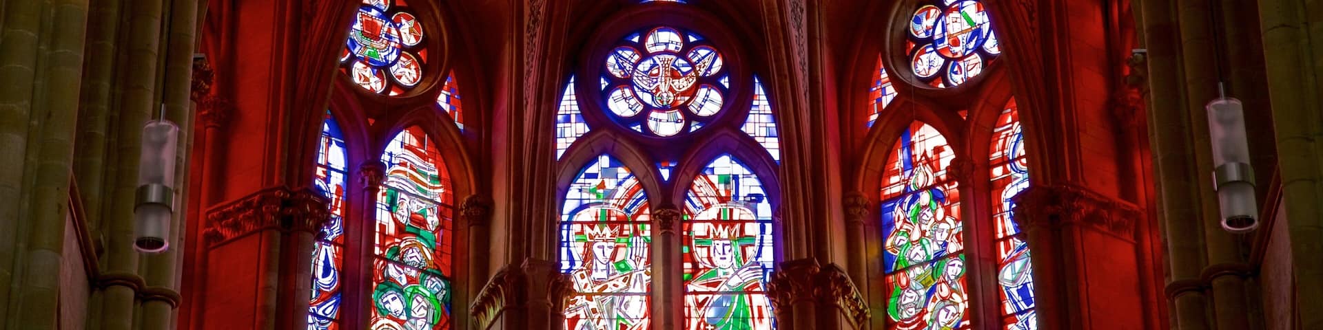 Interior de una catedral con arcos góticos y vidrieras.