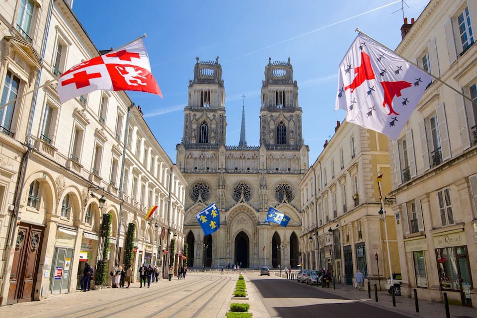 A street with a cathedral and flags.