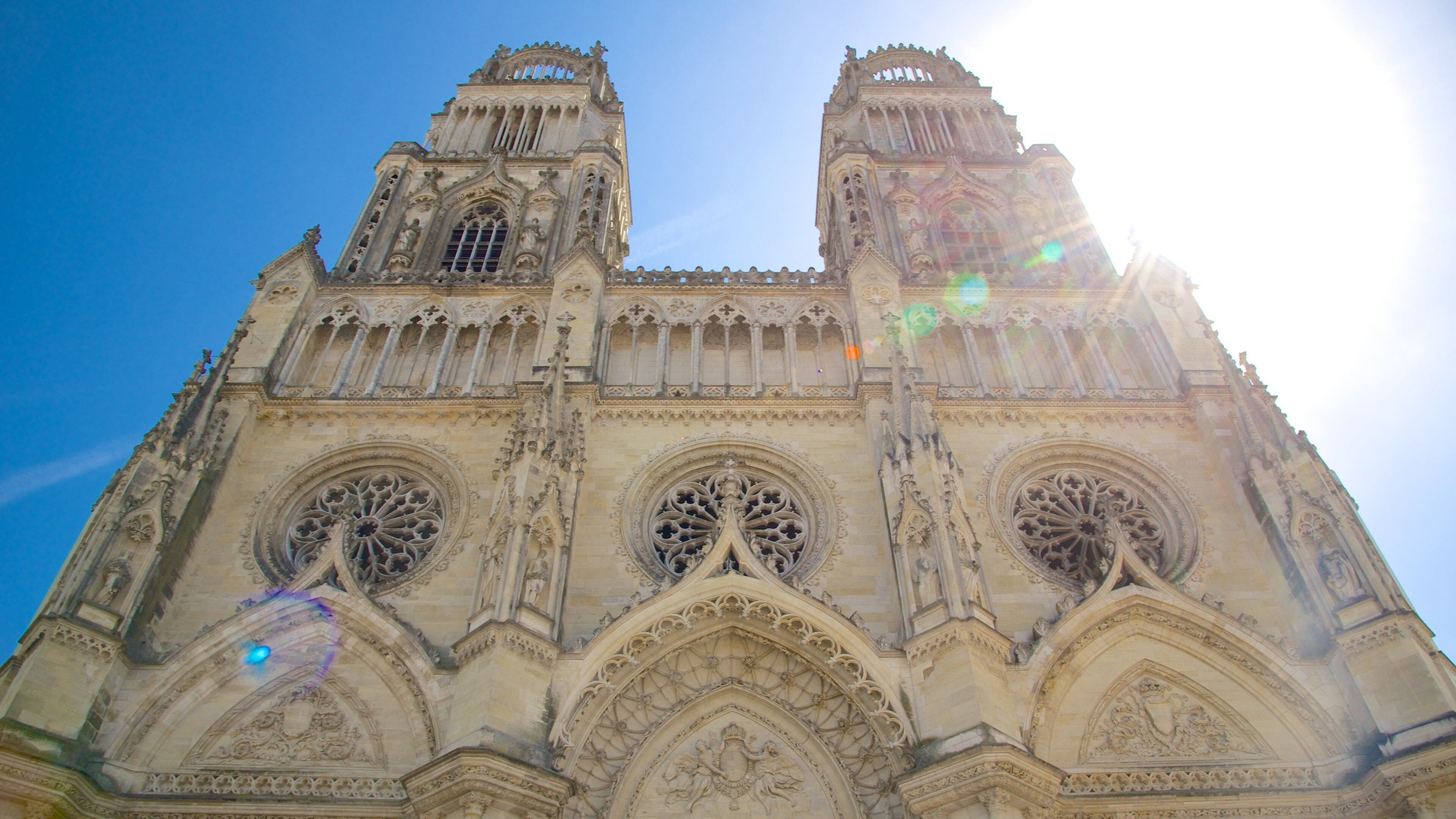 Una catedral gótica con dos torres, elaboradas esculturas de piedra y grandes rosetones.