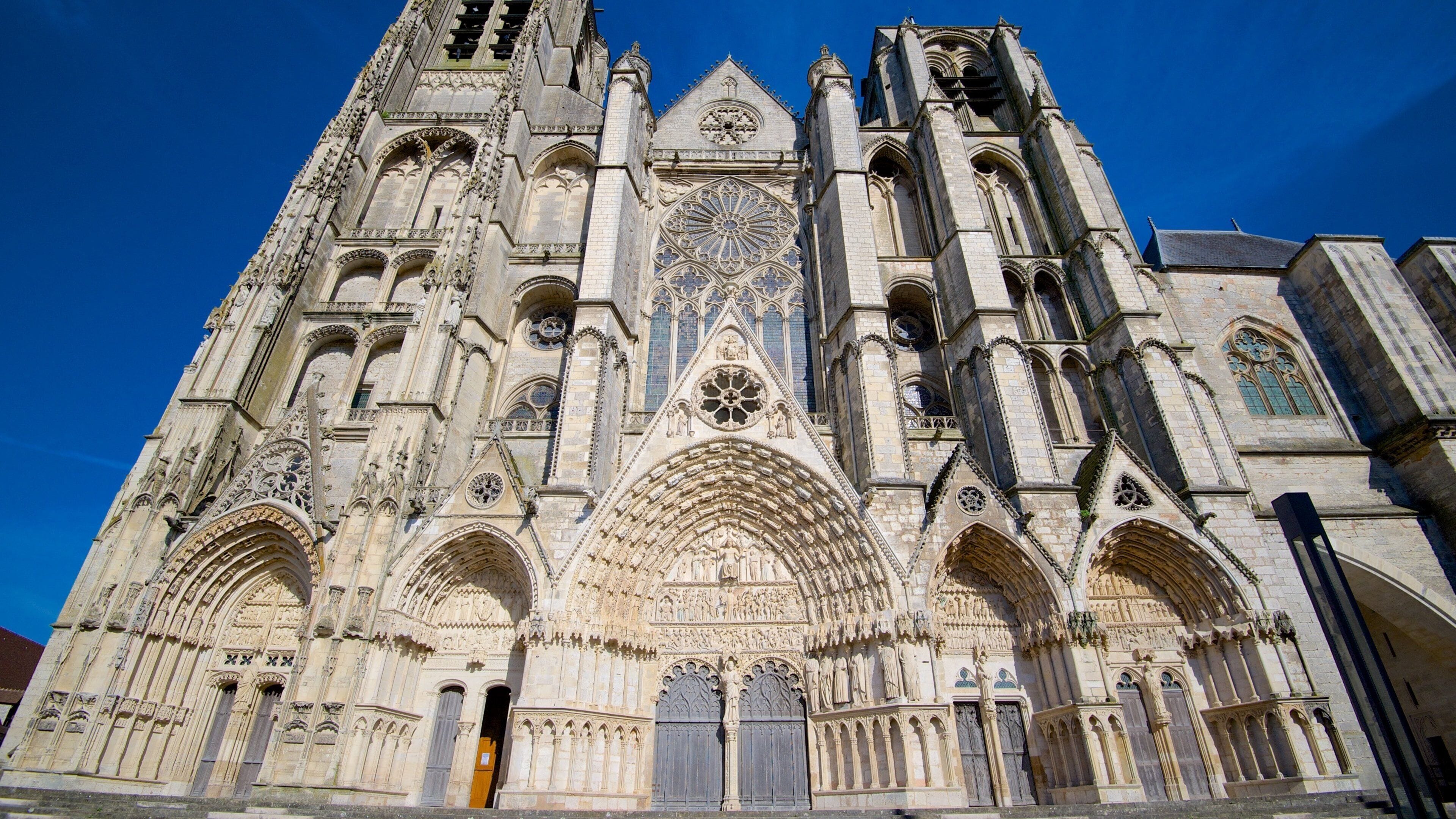 Une cathédrale gothique ornée de sculptures complexes en pierre, de grandes rosaces et d’arcs en ogive.