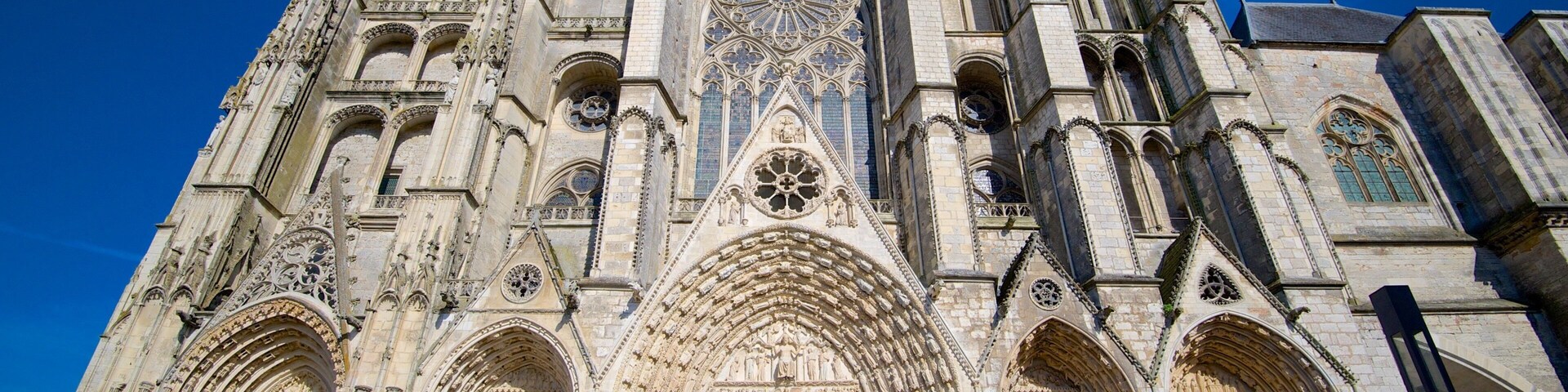 Una catedral gótica con elaboradas esculturas de piedra, grandes rosetones y arcos apuntados.