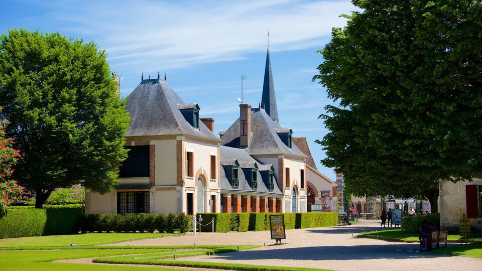 A historic building with a pointed tower and adjacent smaller structures.