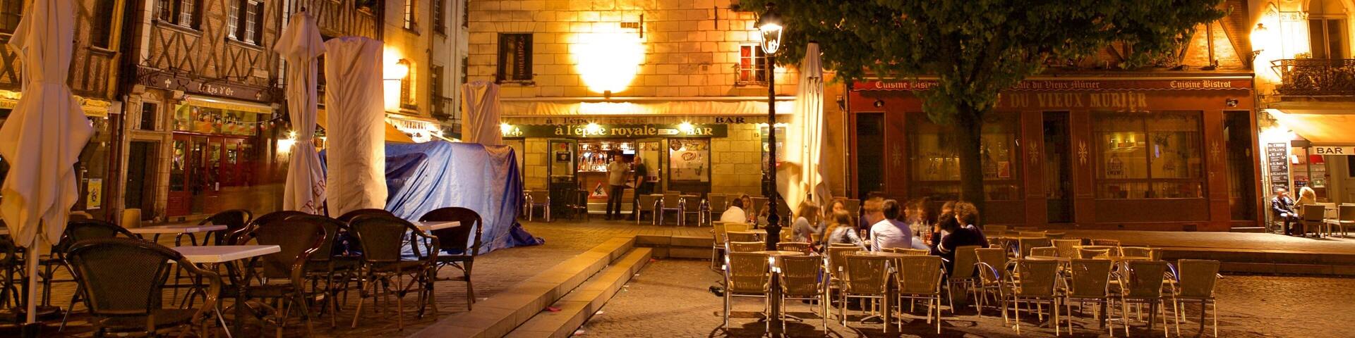 Place Plumereau which includes a square or plaza, outdoor eating and night scenes