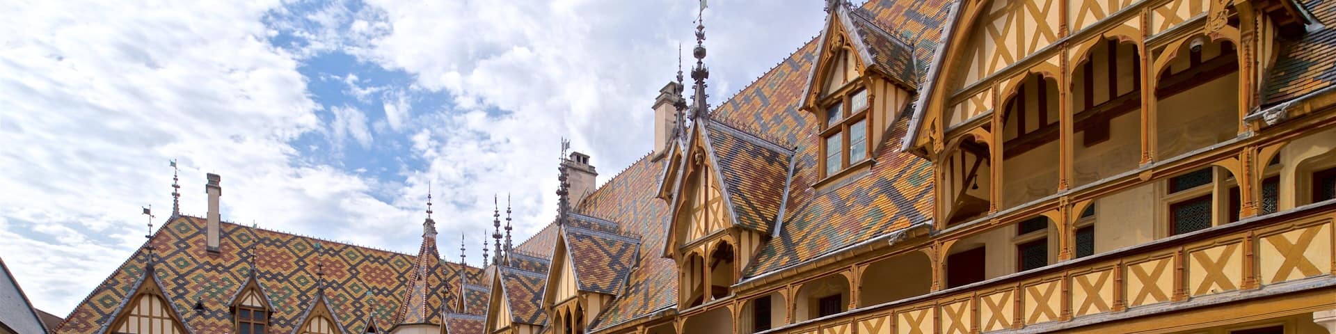 A courtyard with a building featuring a tiled roof and timber framing.