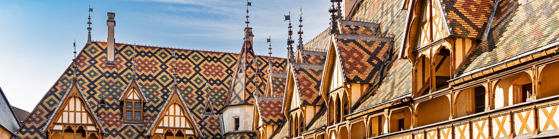 Um pátio com telhado estampado, galeria coberta e um edifício com telhado em duas águas.