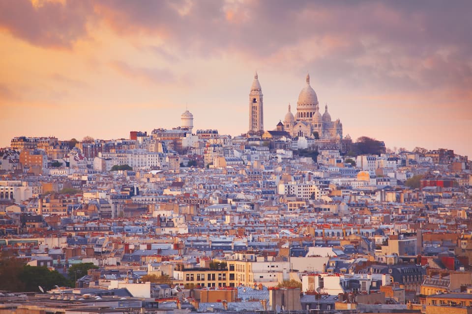 A cityscape with a prominent cathedral and two towers.