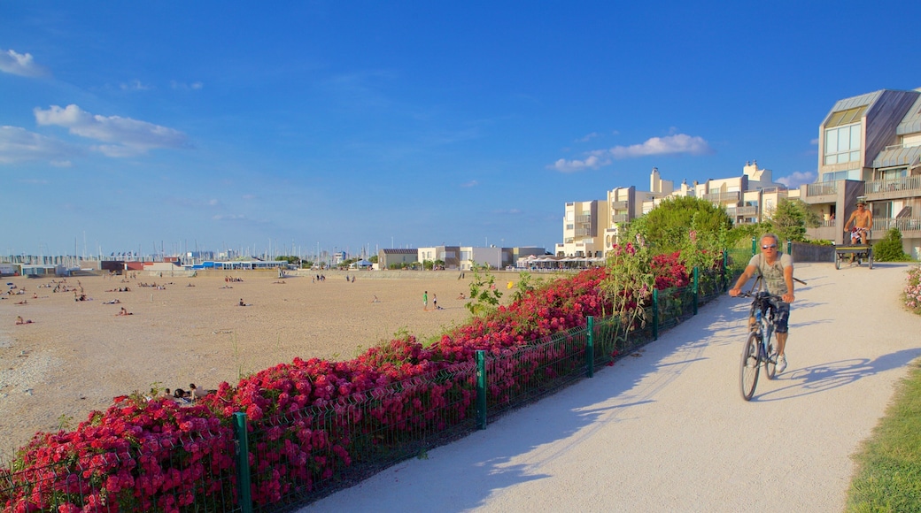 Playa de Minimes ofreciendo flores y una playa y también un hombre
