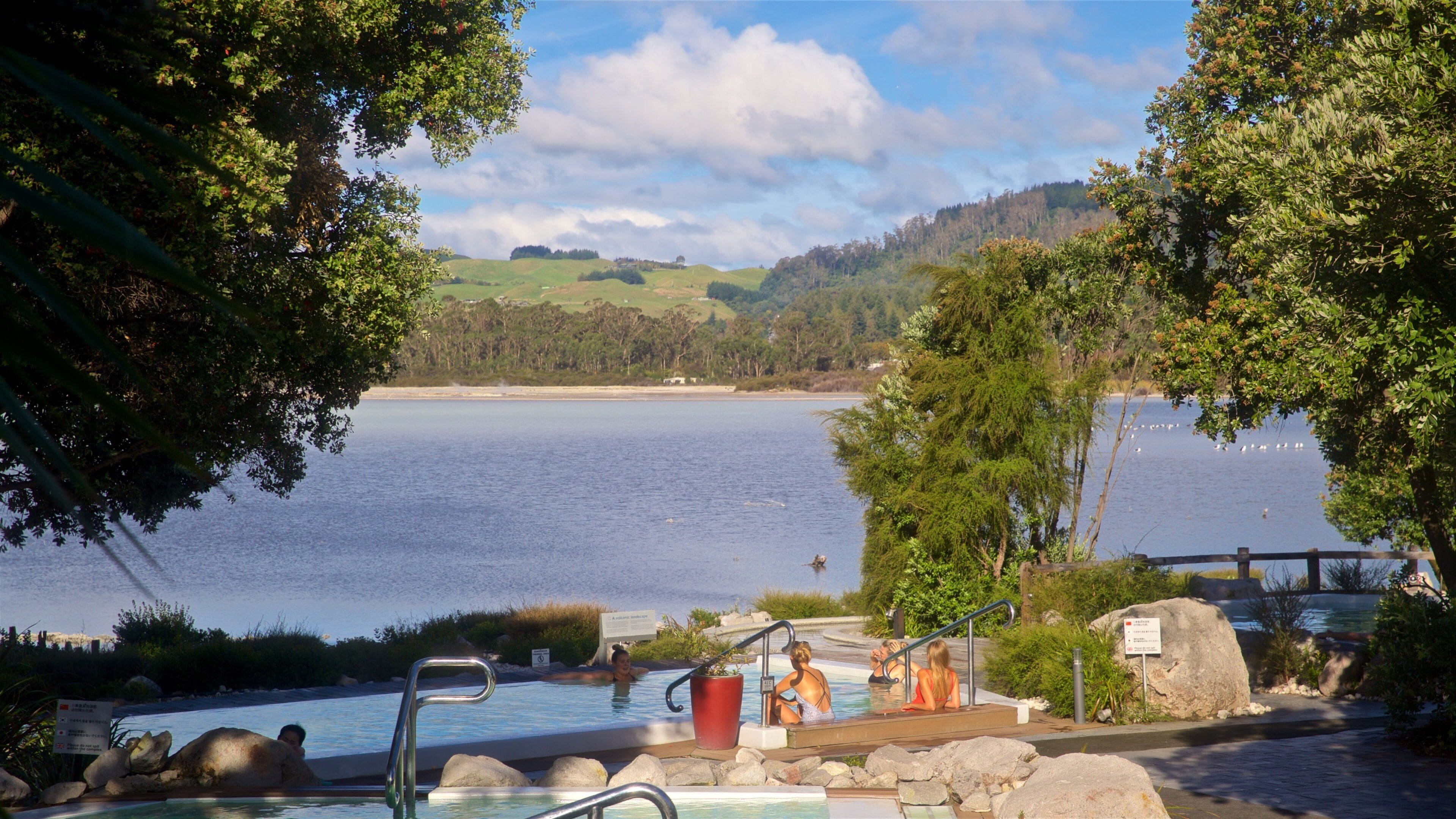 Polynesian Spa featuring a pool and a lake or waterhole as well as a small group of people