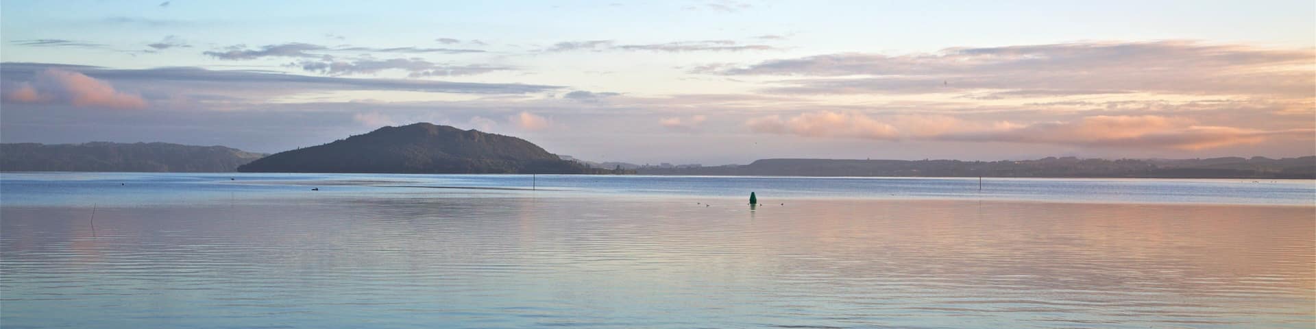 Mokoia Island showing a lake or waterhole and a sunset