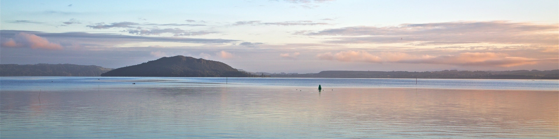 Mokoia Island showing a lake or waterhole and a sunset