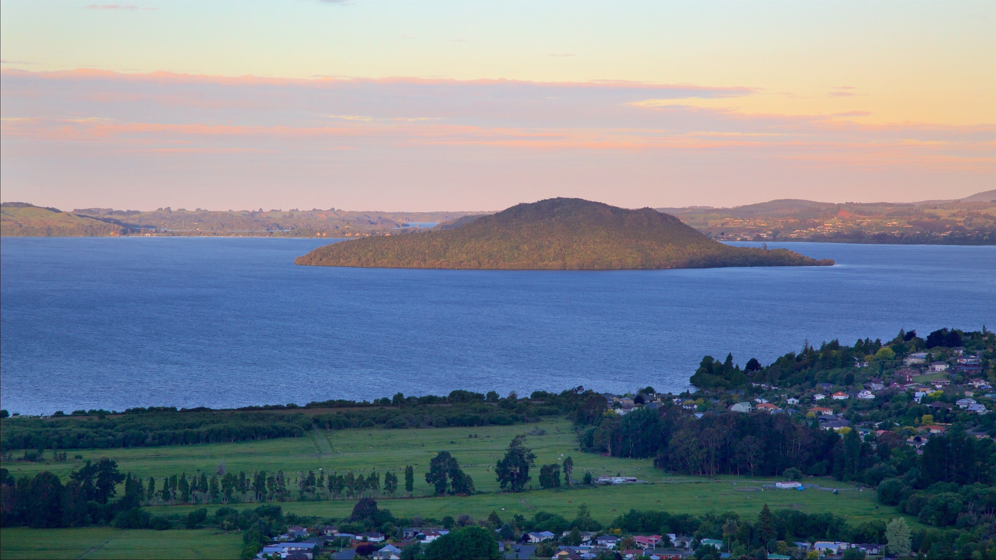 Mokoia Island featuring a small town or village, a sunset and a lake or waterhole