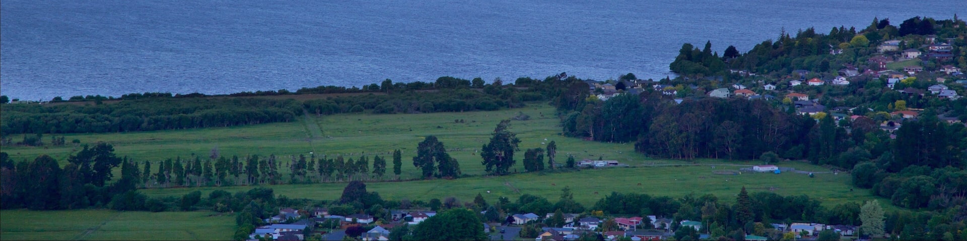 Mokoia Island featuring a small town or village, a sunset and a lake or waterhole