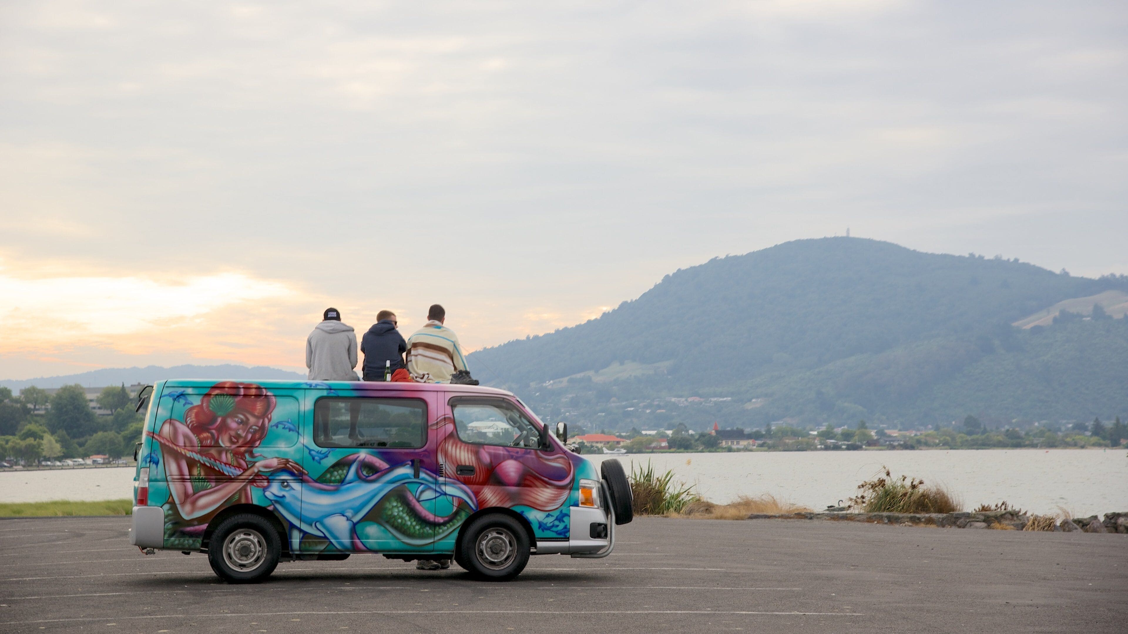Lake Rotorua featuring a lake or waterhole as well as a small group of people