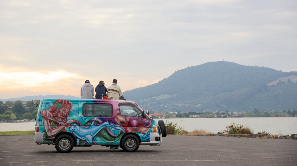 Lake Rotorua featuring a lake or waterhole as well as a small group of people