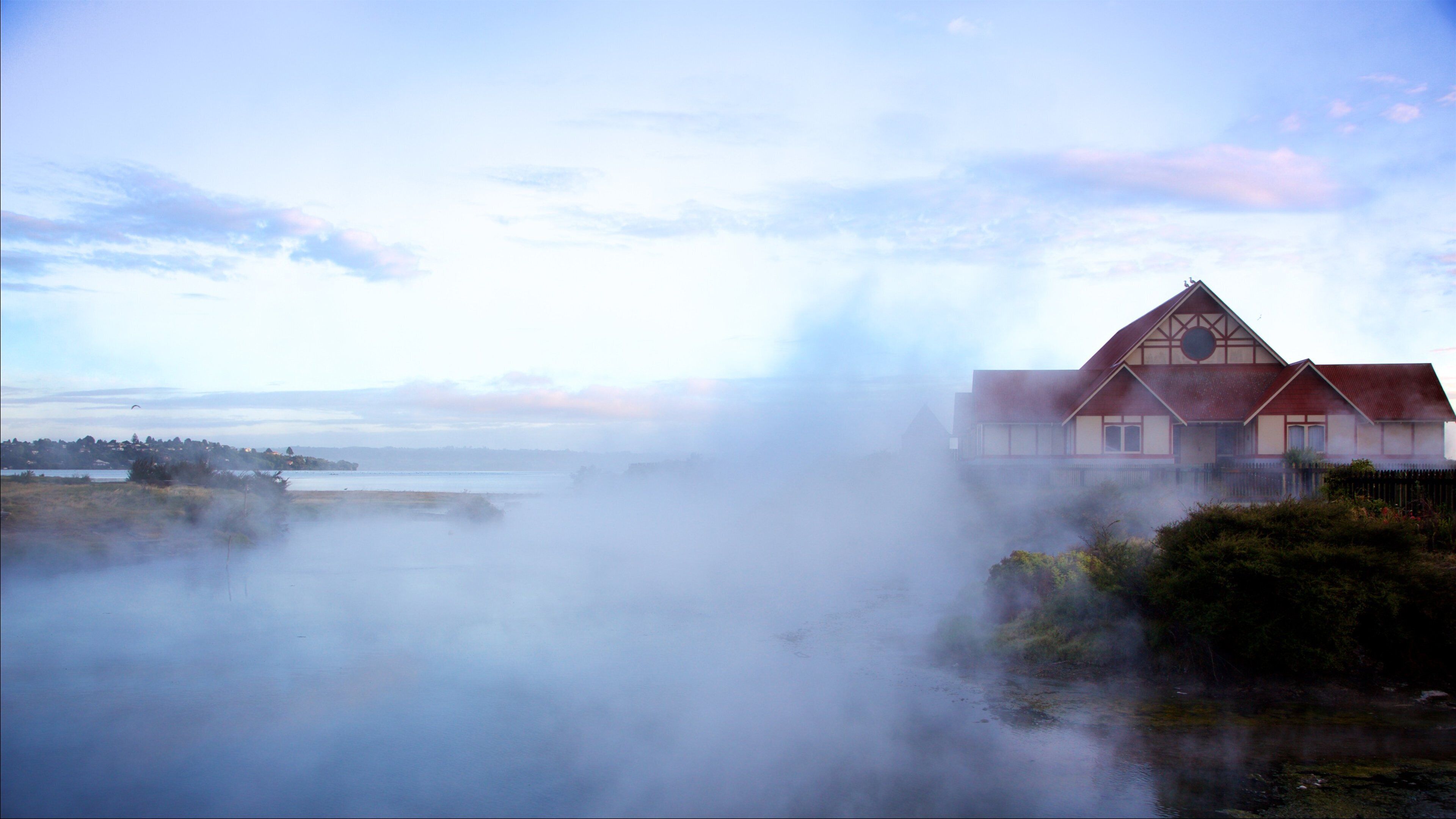 Tama-te-Kapua Meeting House showing a sunset, mist or fog and a hot spring