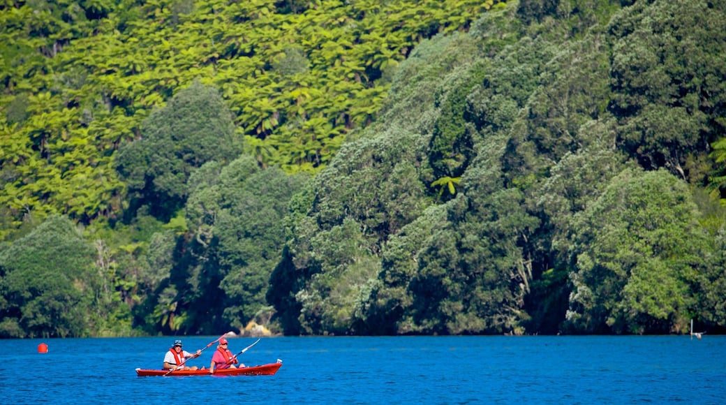 Lake Tarawera featuring a lake or waterhole and kayaking or canoeing as well as a small group of people