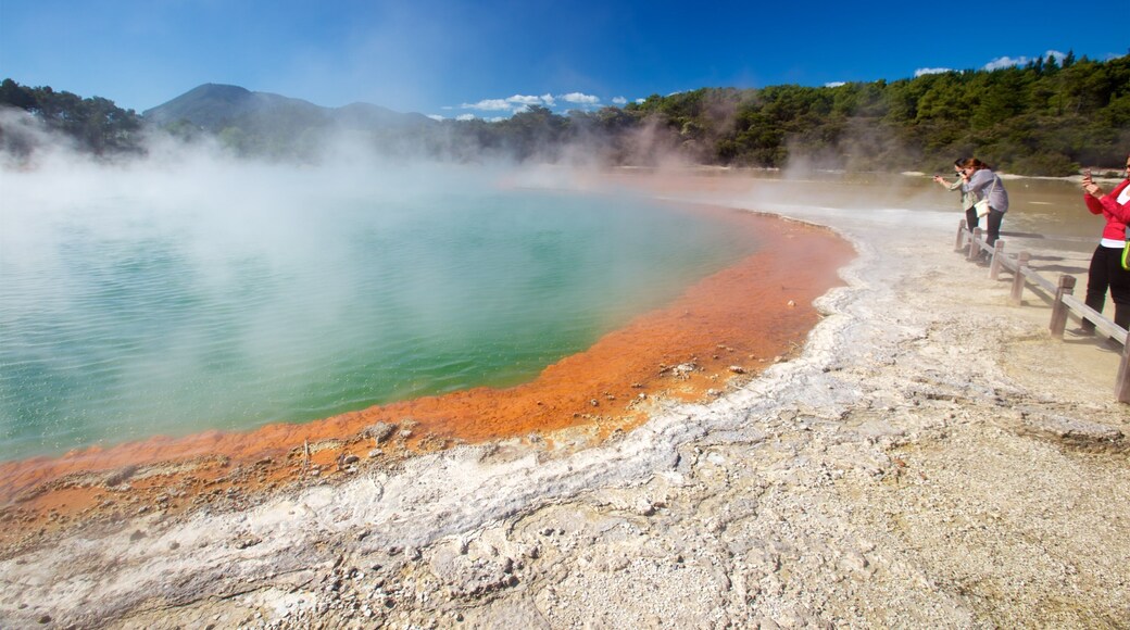 Wai-O-Tapu Thermal Wonderland which includes mist or fog and a hot spring as well as a small group of people