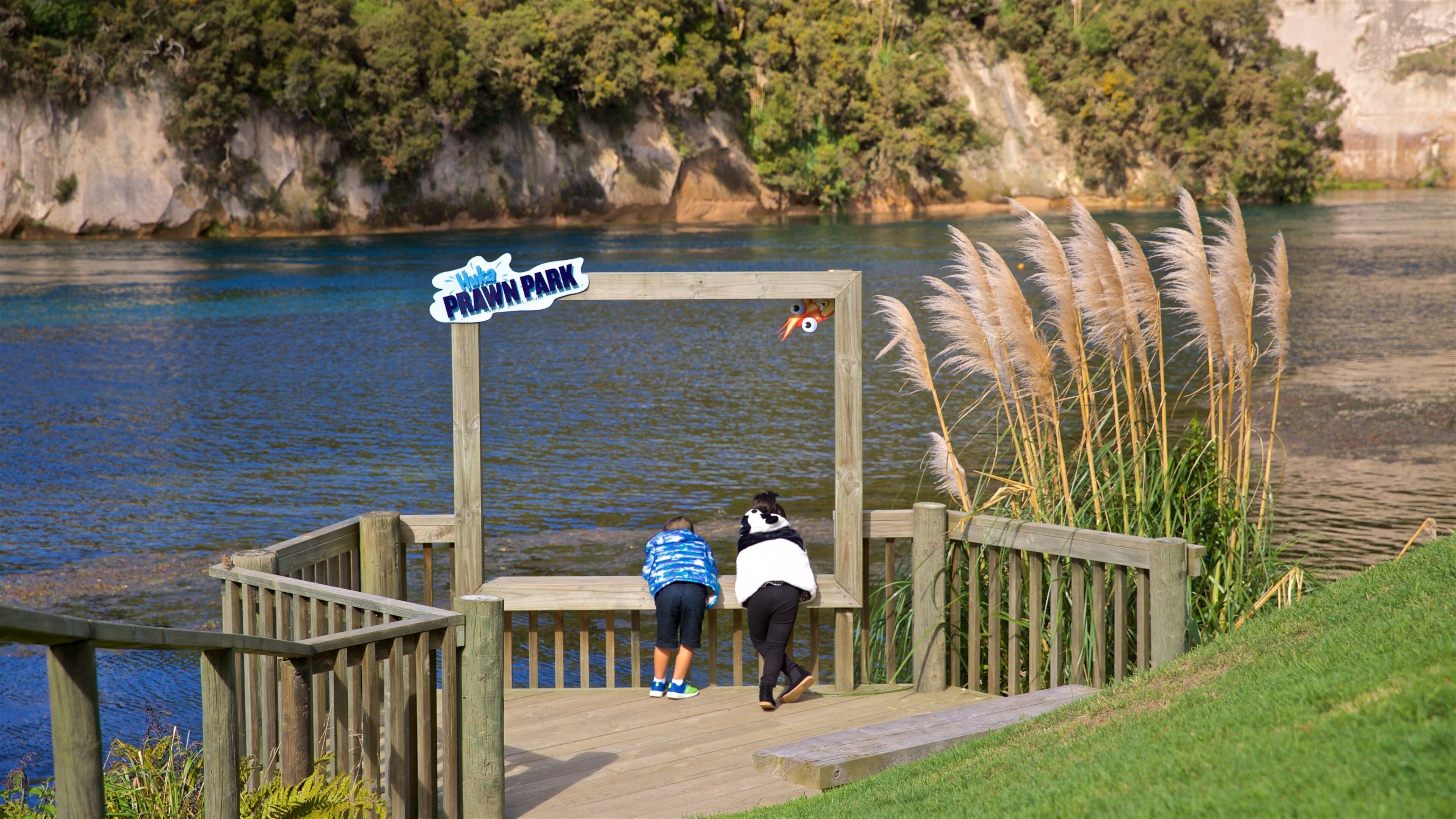 Prawn Farm showing a river or creek and signage as well as a family